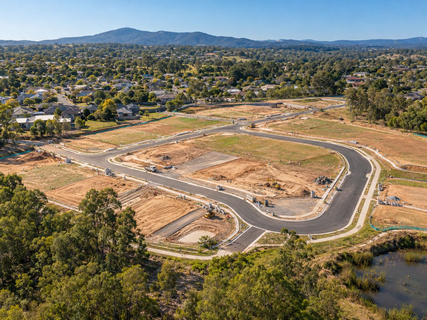 Aerial view of new roads and serviced lots taking shape on the edge of a town